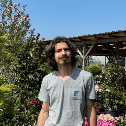 Portrait travailleur handicapé jardinerie horticulture devant rayon extérieur