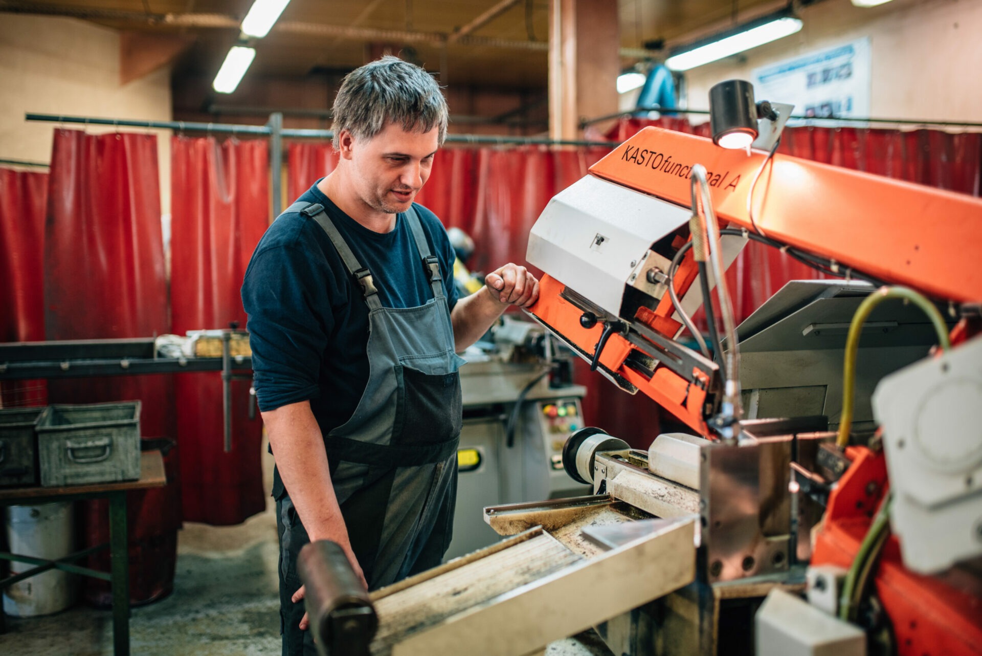 Portrait travailleur handicapé metallerie devant une machine scie à ruban