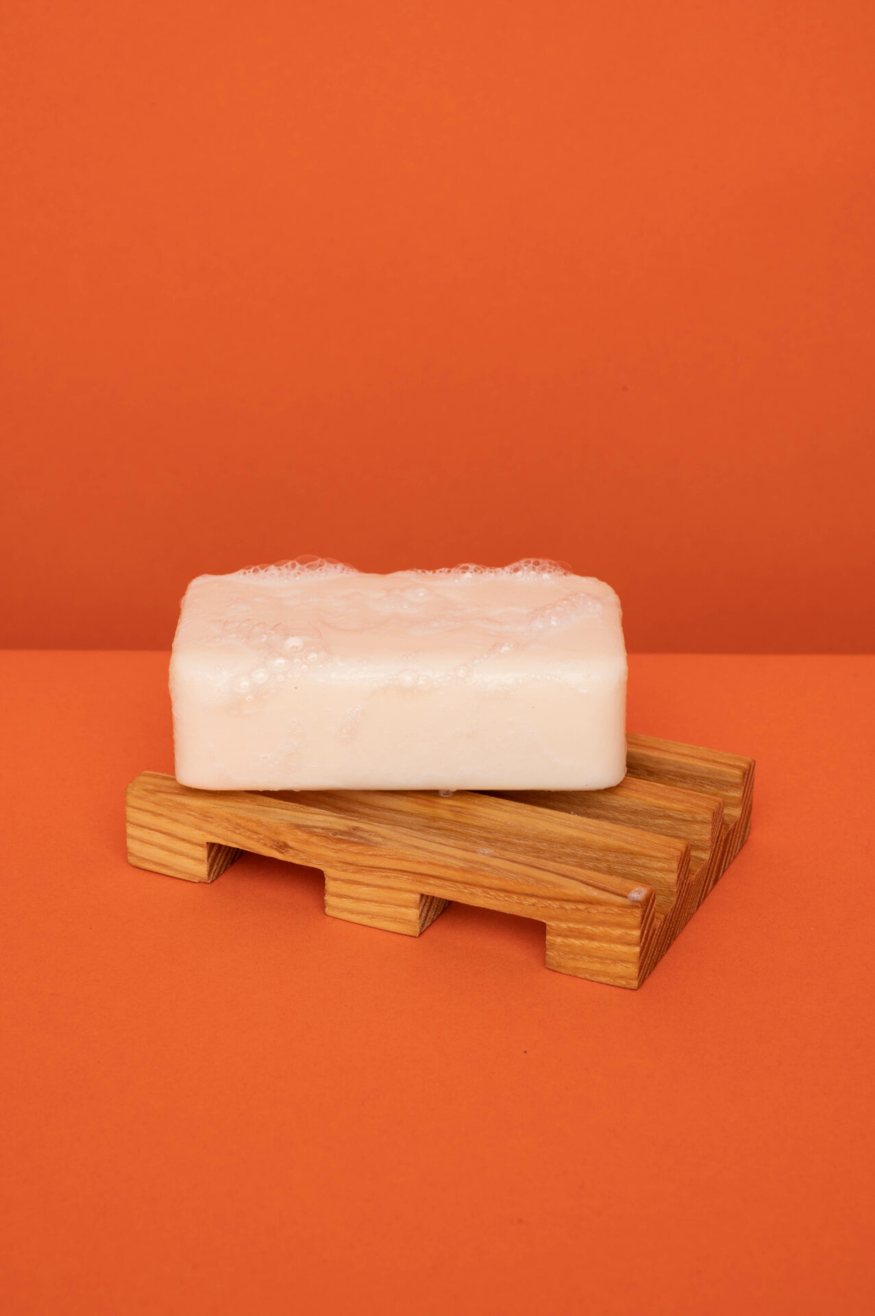 Production propre Sonnenhof - porte-savon en bois sur fond de couleur