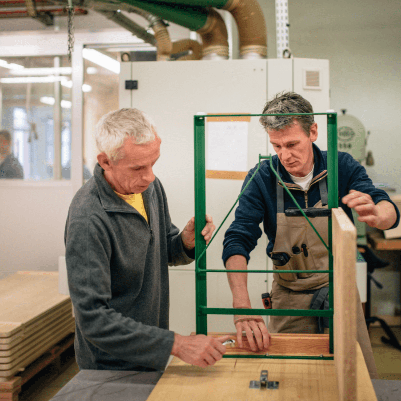 Moniteur menuiserie rélisant avec travailleur handicapé le montage d'une table