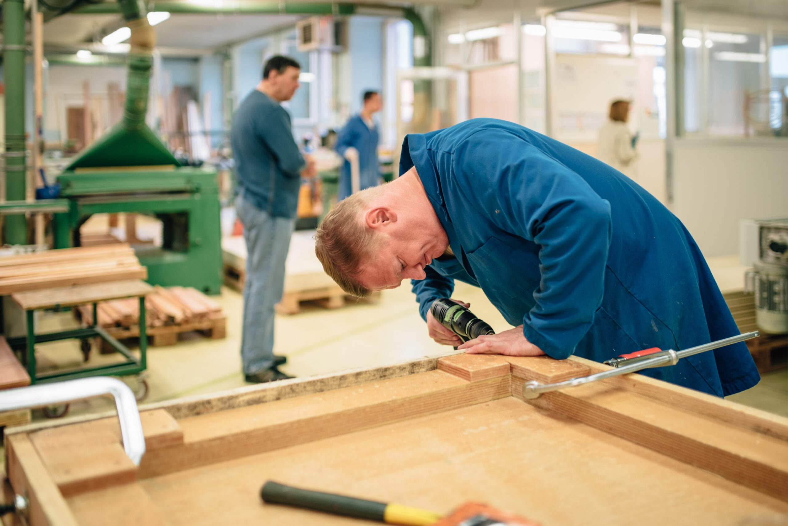 Menuiserie Sonnenhof -travailleur hanciapé en train de visser bois pour montage