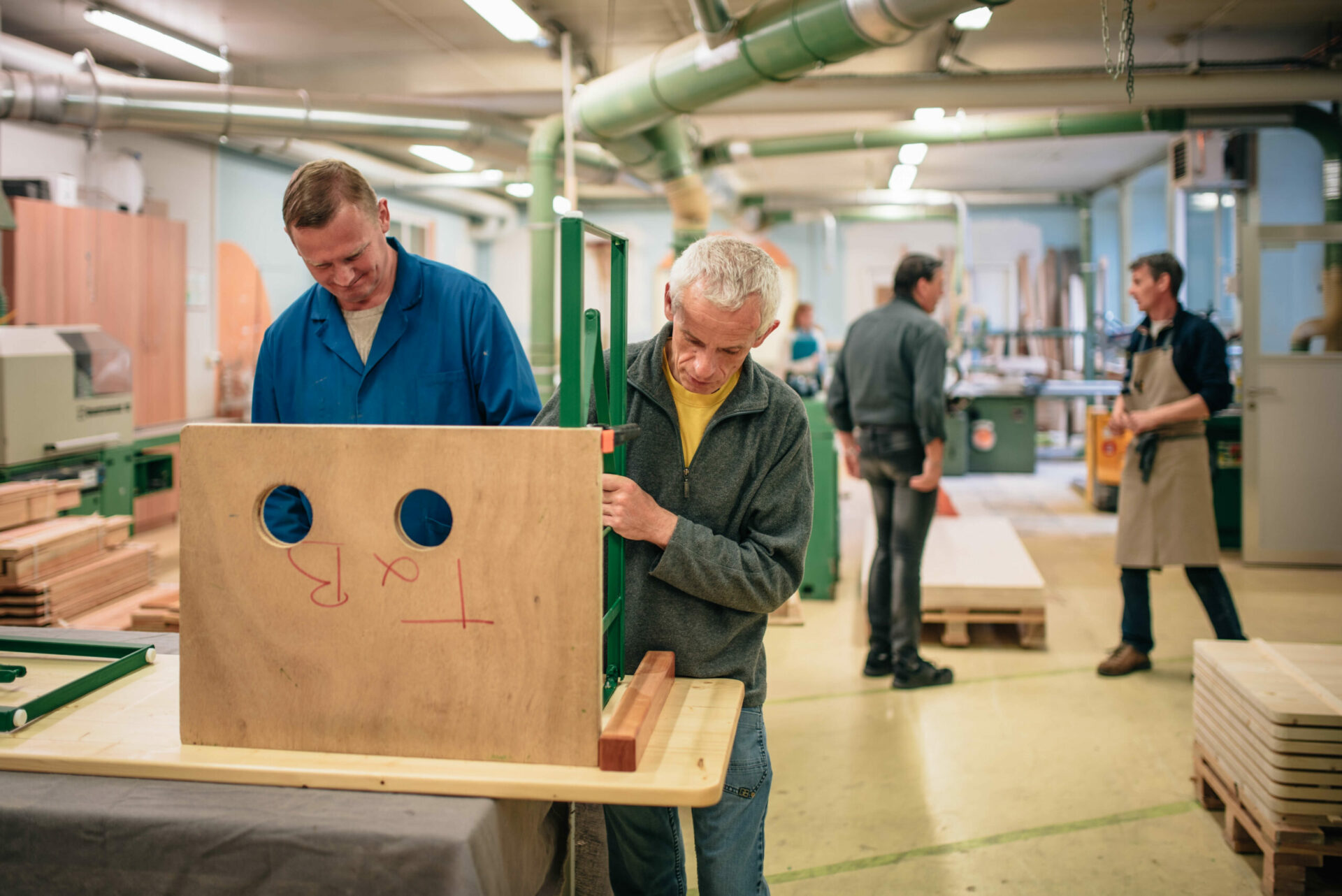 Menuiserie Sonnenhof -deux travailleurs hanciapés travaillant ensemble au montage d'une table en bois