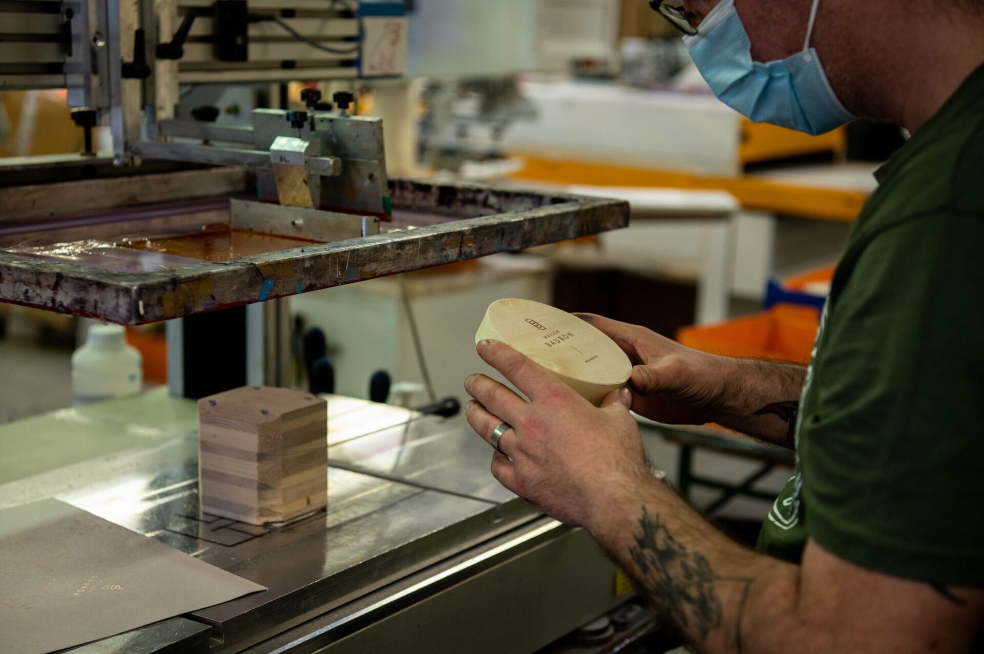 Prestation Sonnenhof -travailleur handicapé préparant le marquage par sérigraphie d'une boite ronde en bois